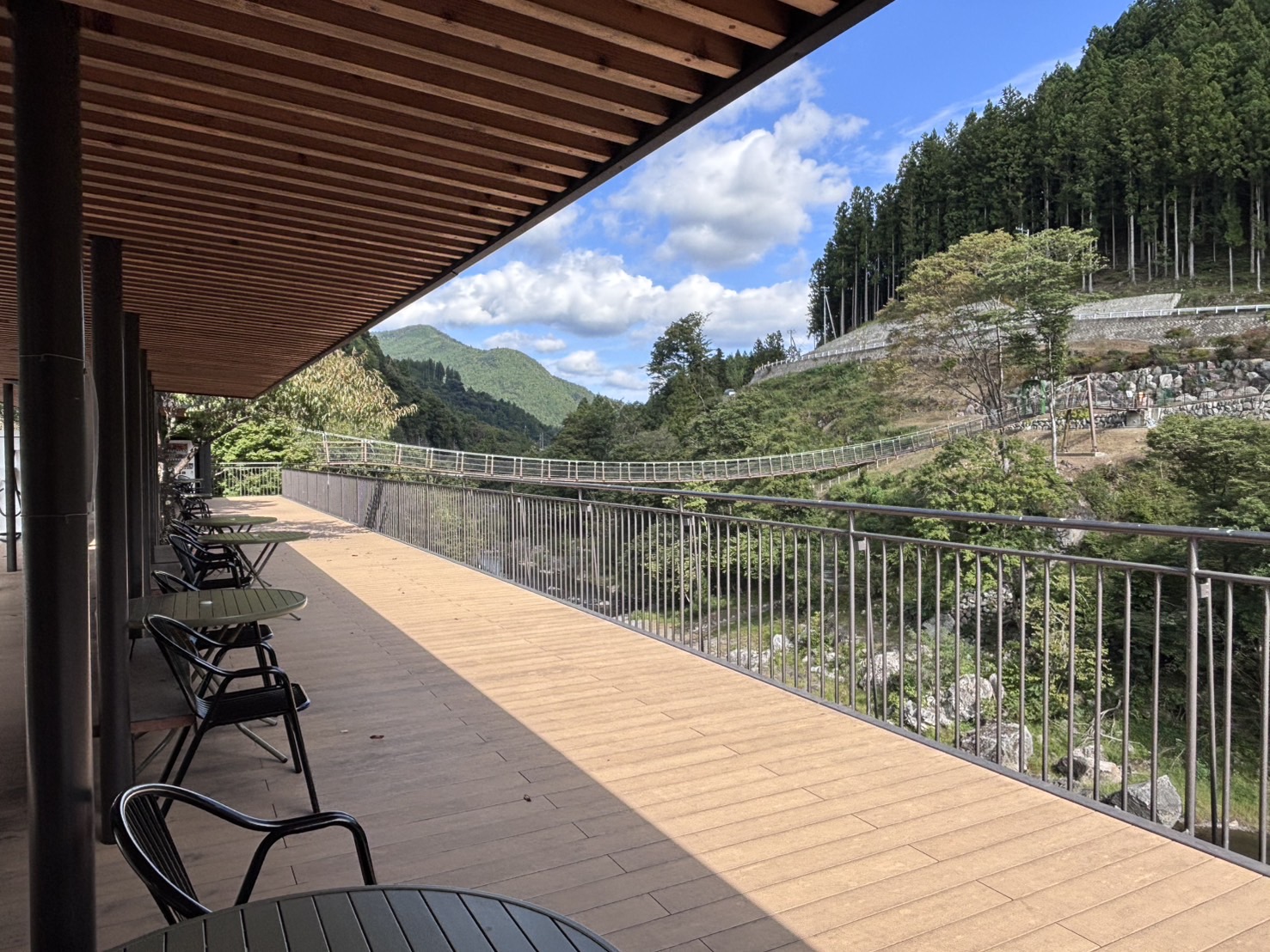 晴天のもと新緑に囲まれたテラスで神流川を眺められる